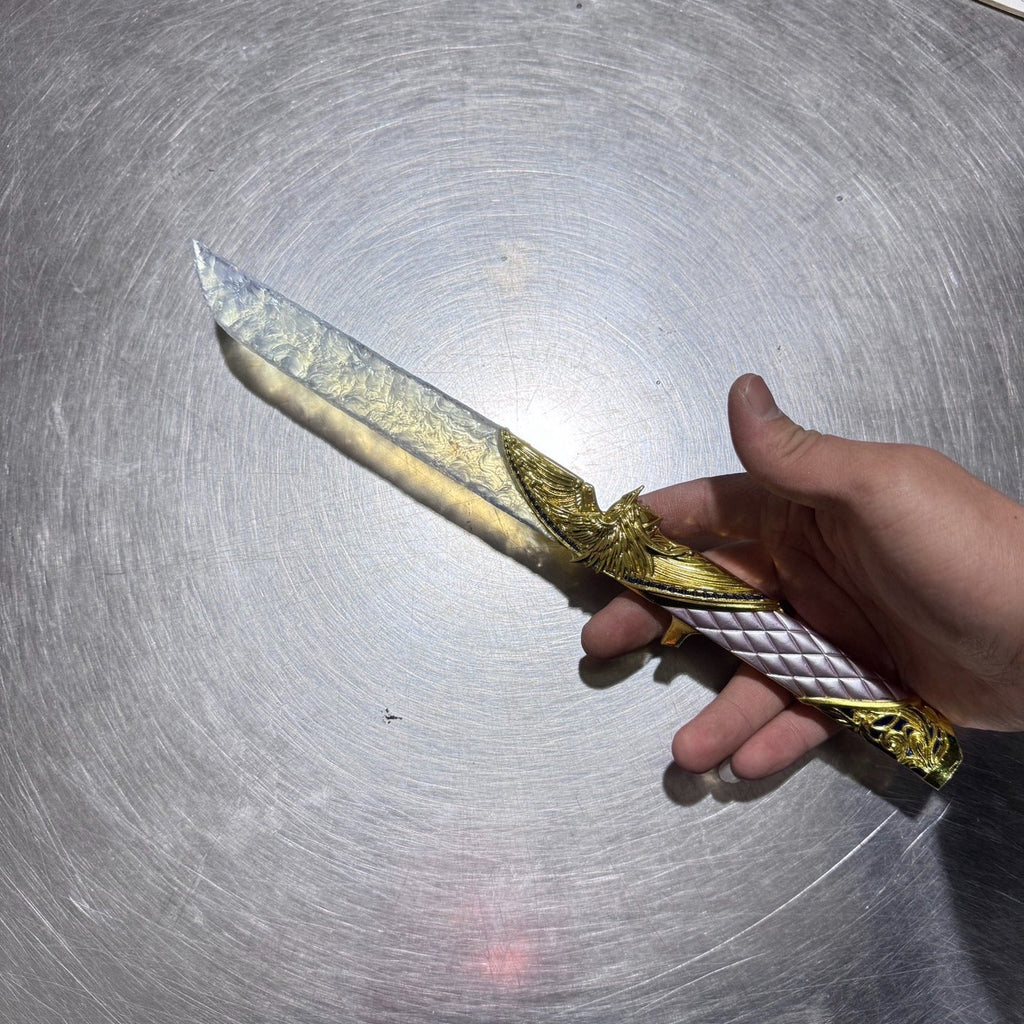 Dark Star: Angel Edition Dagger - Premium hand-forged replica with iridescent opal-inspired blade and solid gold metal hilt, isolated on pure black background.